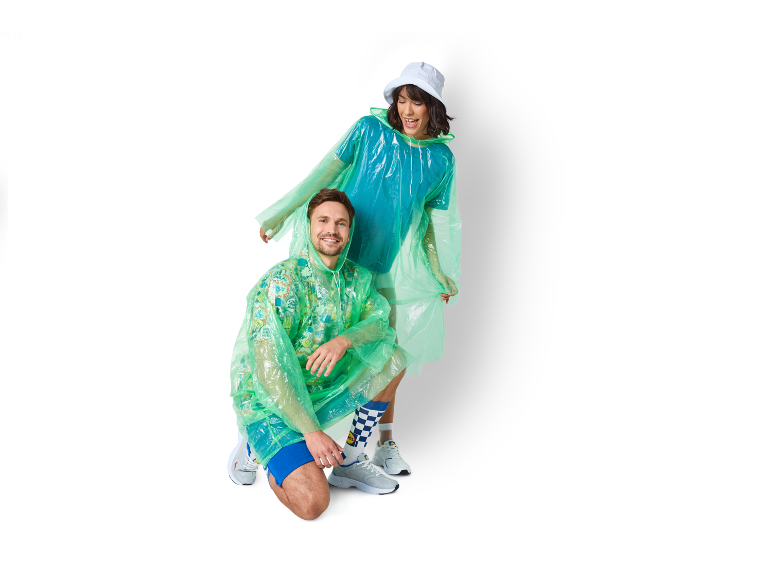 Two people wearing rain ponchos and matching socks, smiling.