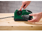 Man using an electric drill sharpener on a wooden workbench.