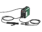 Green welding machine with cables and clamps on a black background.