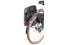 Gray bicycle pannier with red taillight and brown tire on a bike.