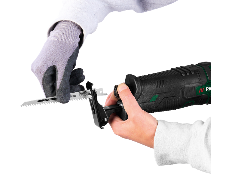Gloved hands insert a saw blade into a reciprocating saw.