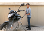 Man cleaning a motorcycle with a pressure washer