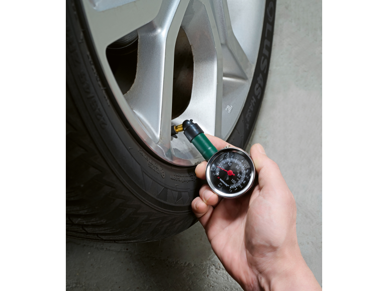 Tyre pressure gauge checking the pressure in a car tyre.