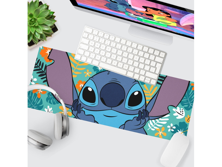 Desk setup with a Stitch-themed mouse pad, keyboard, mouse, headphones, and a monitor.