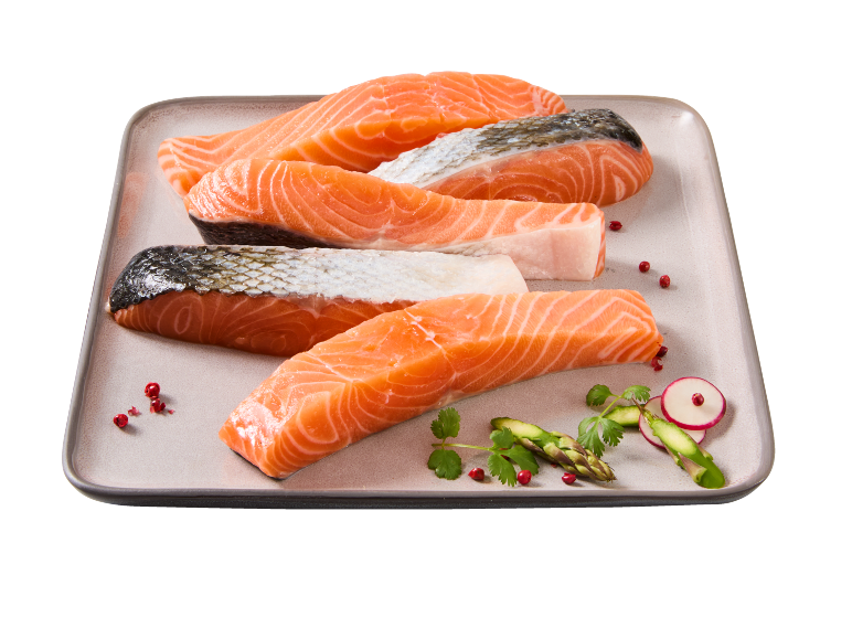 Fresh salmon fillets with skin and skinless, garnished with asparagus and radish.