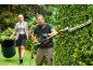 Man trimming hedge with a hedge trimmer, woman carrying a collapsible garden waste bag.