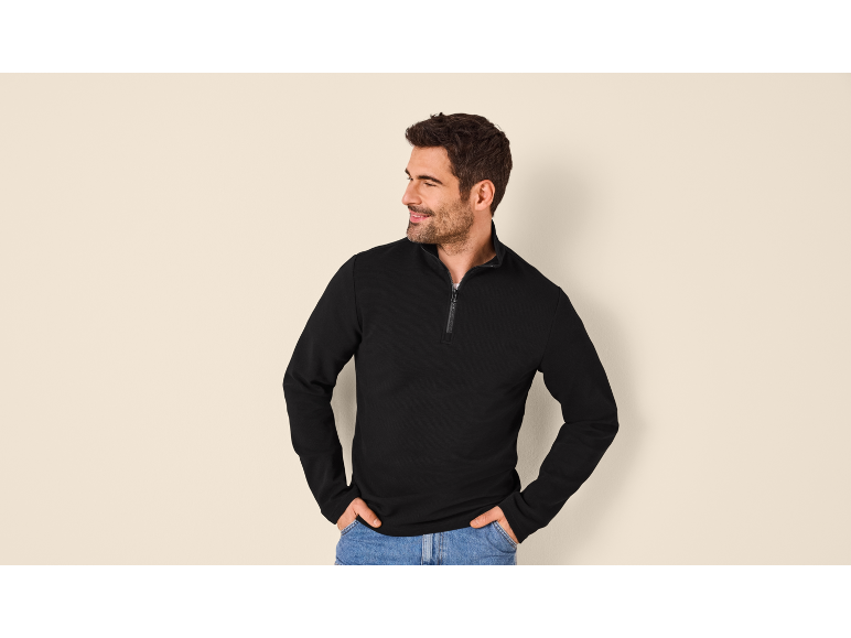 Man in black zip-up sweatshirt and jeans
