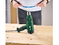 Woman holding wires while a heat gun rests on a table.