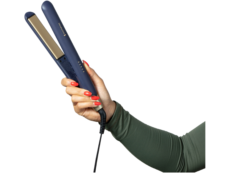 Woman's hand holds a blue hair straightener with gold plates.