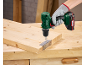 A cordless drill is used to attach a hinge to a wooden board.