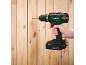 Cordless drill in hand, drilling into a wooden wall.