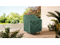 Green protective cover for garden furniture on a wooden terrace.