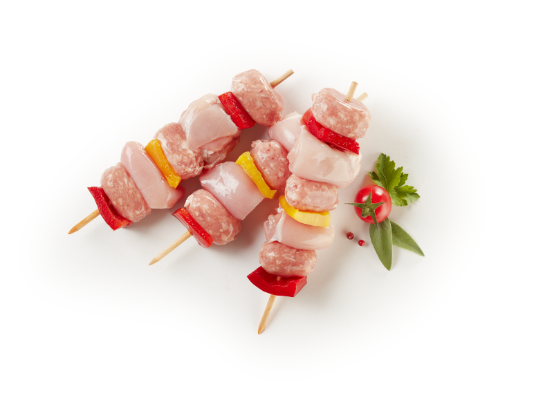 Raw chicken and minced meat skewers with peppers, garnished with tomato and herbs.