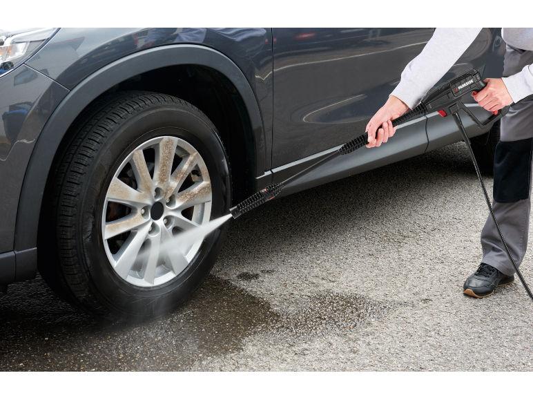 Pressure washer cleaning a dirty car wheel.