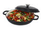 Cast iron pan with vegetables: zucchini, bell peppers, onions, and basil.