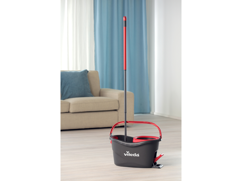 Mop and bucket with wringer in a modern living room.
