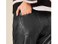 Woman in black leather trousers and striped jumper, hand in pocket.