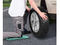 Man changing a car tire, kneeling on a kneeling pad.