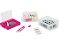 Sewing kit with thread boxes, needles, scissors, and accessories in fuchsia and clear.