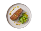 Grilled steak with salad and spicy dressing on a plate.