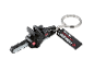Chainsaw-shaped keychain in black with red accents, featuring the text 'PERFORMANCE EST. 1996'.