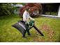Woman using a leaf blower with a leaf collection bag in a garden.