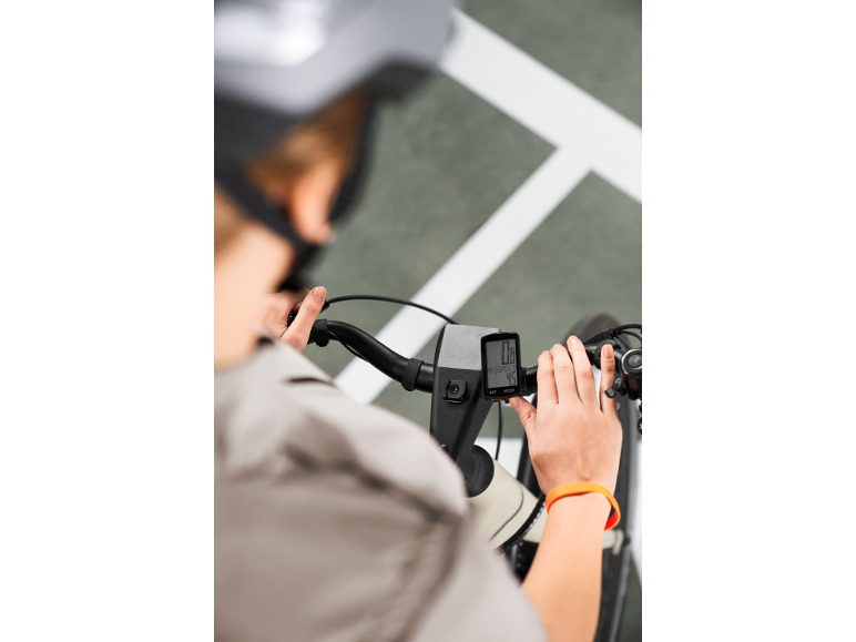 Person on bike looking at a bike computer with speed readings of 0.0 and 4.5.
