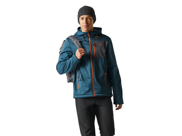 Man in blue jacket with orange zippers, black beanie, and backpack.
