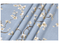 Light blue textile with a pattern of blooming cherry branches.
