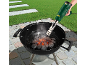 Electric charcoal starter for barbecue, igniting charcoal in a grill in a garden.