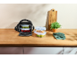 Picnic bag with food containers filled with fruit and vegetables on a wooden counter.