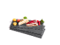 Cake slices and macarons on slate platters, garnished with raspberries and mint.