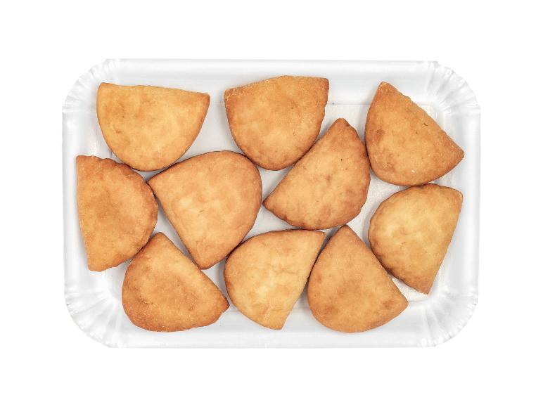 Fried empanadas in a white tray, viewed from above.
