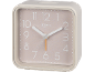Beige square alarm clock with white numbers and hands.