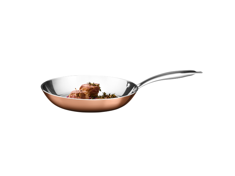 Copper frying pan with beef fillet and herbs.