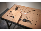 Workbench with a wooden board secured by clamps.
