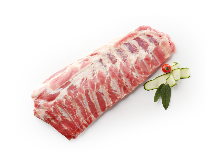 Raw pork ribs with tomato, zucchini, and sage on a dark background.