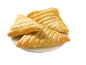 Three golden puff pastry turnovers on a white plate