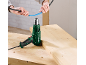 Hands holding a blue heat shrink tube over a heat gun on a wooden workbench.