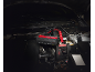 Car jump starter connected to a car battery under the open hood.