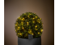 Artificial boxwood with solar LED lights in a dark pot.