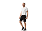 Man in white t-shirt and black shorts, posing sideways