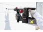 Cordless hammer drill drilling into a white brick wall