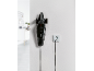 Black cordless handheld vacuum cleaner, hanging on the wall and charging.