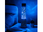 Blue tower lamp with thematic figures, on a nightstand next to a bed.