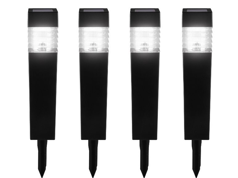 Four black solar-powered garden path lights with illuminated tops.