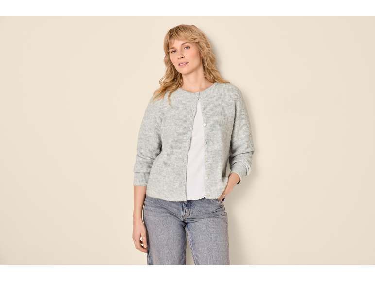 Woman in a grey knitted cardigan, white t-shirt, and blue jeans.