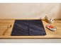 Dark hob protectors on a wooden countertop with kitchen utensils.