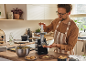 Man making cookies with a cookie maker machine in the kitchen.