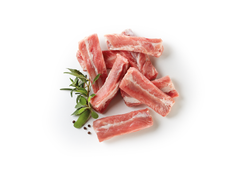 Raw pork ribs with herbs and peppercorns on a white background.